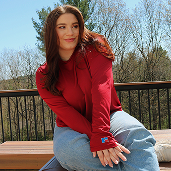 Female model wearing a red long sleeve Russell Tee with jeans. 
